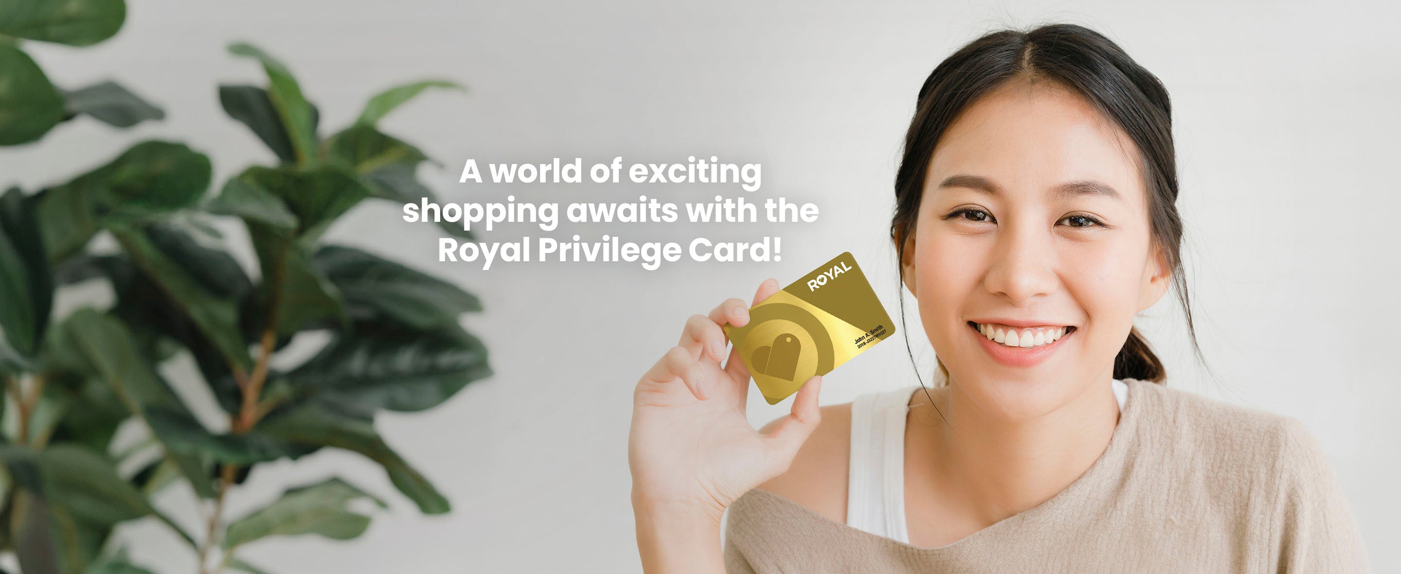 A woman holding a gold Royal Privilege Card with text on the left side "A world of exciting shopping awaits with the Royal Privilege Card!" 